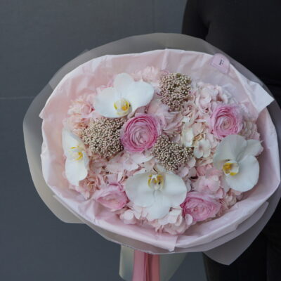 Букет з рожевих гортензій, ранункулюсів, орхідей та озотамнусу