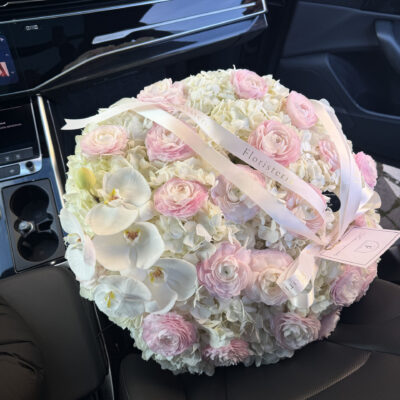 Ніжна композиція в плетеному кошику з білих гортензій, ранункулюсів та орхідей