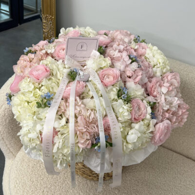 Збірна композиція в плетеному кошику з гортензій, ранункулюсів  та оксипеталума