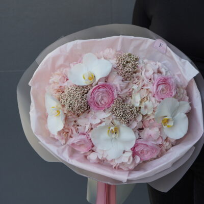 Букет з рожевих гортензій, ранункулюсів, орхідей та озотамнусу