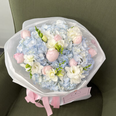 Букет з блакитних гортензій, фрезій та піоновидних троянд