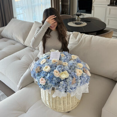 Ніжна композиція в корзині з блакитних гортензій, ранункулюсів і озотамнусу